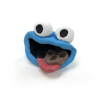 Sculpture of a Blue Monster with Large Round Eyes and Cookie in Mouth
